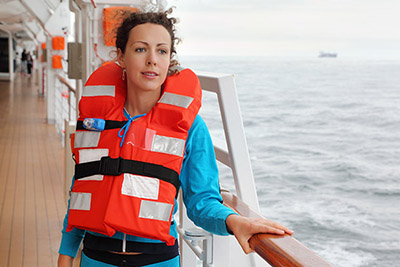 Woman Wearing a Life Vest on a Cruise Ship Deck (Photo: Pavel L Photo and Video/Shutterstock)